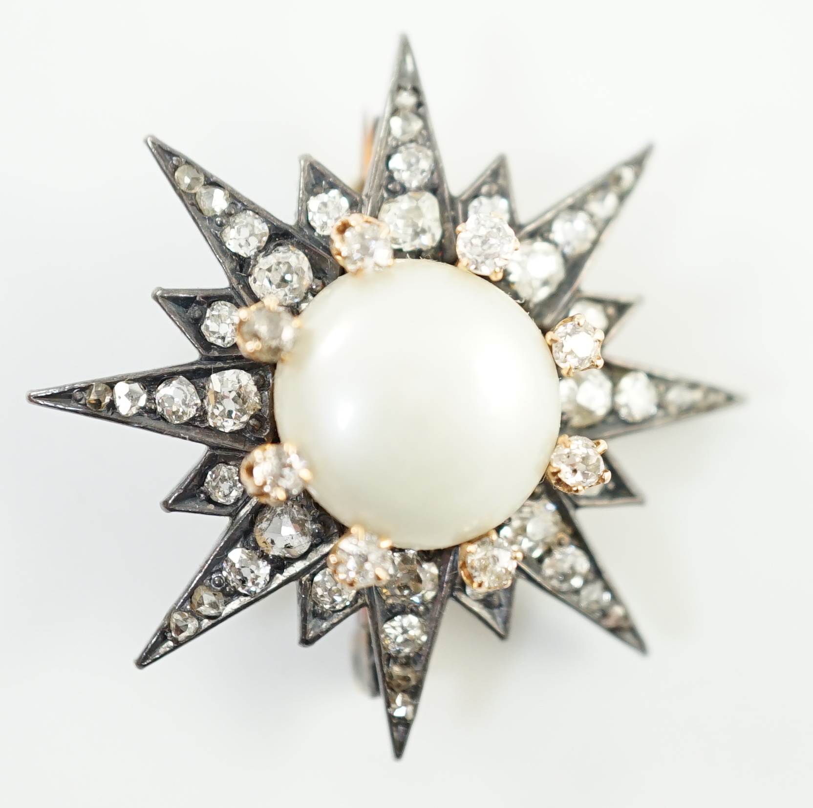 A Victorian gold and silver, button pearl and graduated round and rose cut diamond set cluster starburst brooch